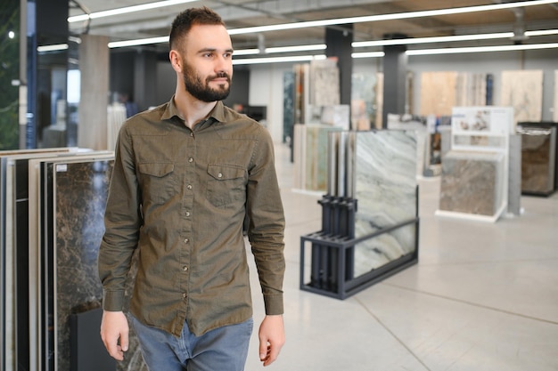 Photo un homme choisissant des carreaux parmi différents échantillons dans le magasin