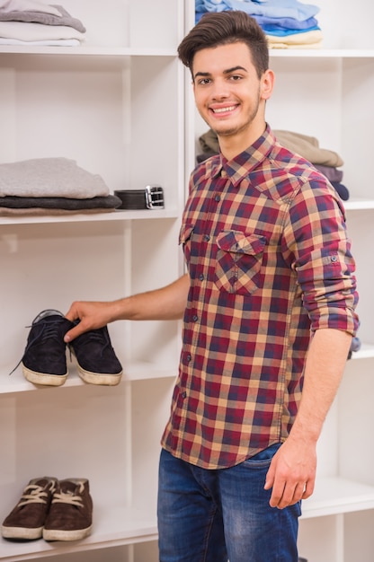 Homme choisissant des chaussures dans le vestiaire et souriant