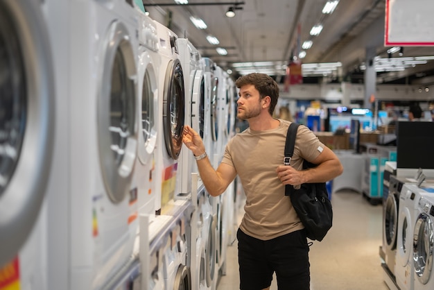 Homme choisissant la machine à laver dans la boutique