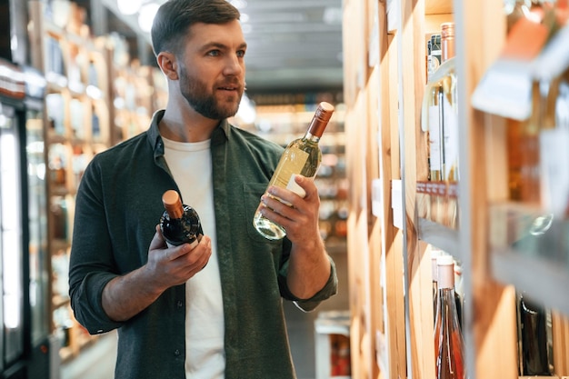 L'homme choisit du vin dans le magasin