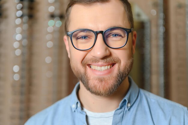 L'homme choisit des lunettes dans un magasin d'optique