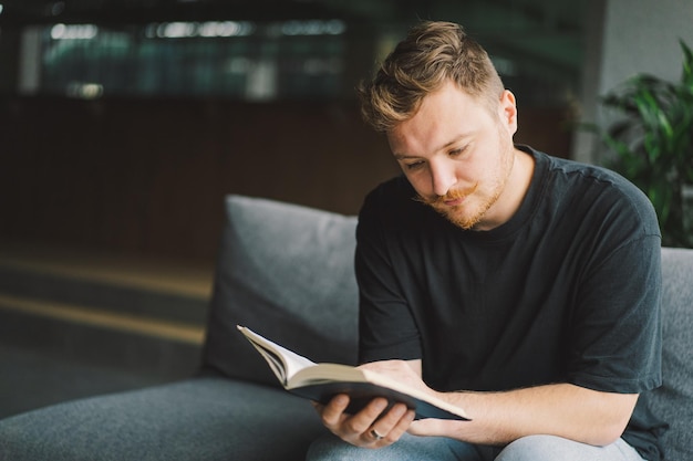 L'homme chrétien tient la Sainte Bible dans les mains Lire la Sainte Bible dans une maison Concept pour la foi, la spiritualité et la religion L'espoir de paix