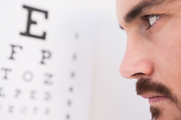 Homme ciblé sur les lettres de test oculaire