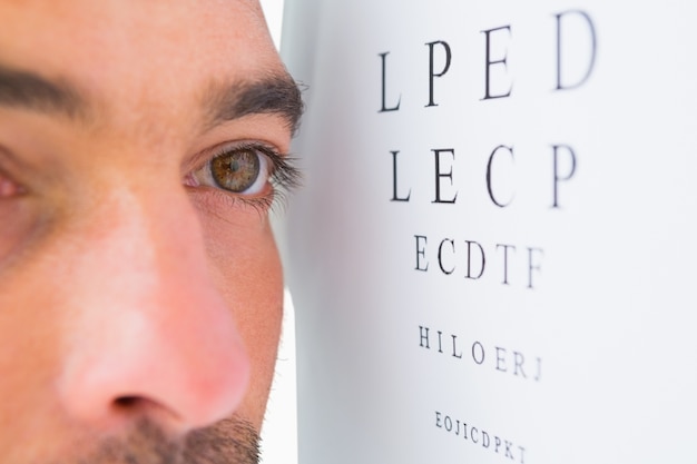 Homme ciblé sur les lettres de test oculaire