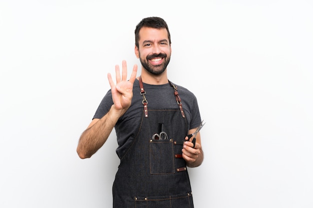 Homme de coiffeur dans un tablier heureux et comptant quatre avec les doigts