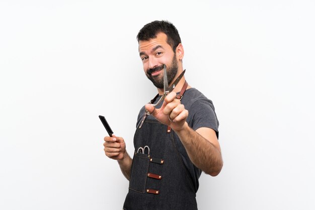 Homme coiffeur dans un tablier sur un mur blanc isolé