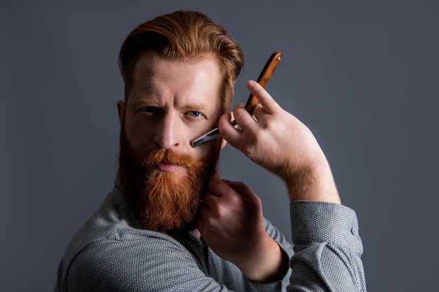 Homme coiffeur faire coupe de cheveux isolé sur fond gris coiffeur homme avec lame pour faire la coupe de cheveux