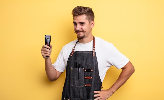 Homme de coiffeur hipster souriant joyeusement avec une main sur la hanche et confiant