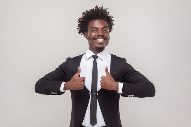 Un homme avec une coiffure afro faisant comme un geste garde le pouce levé en signe d'approbation donne une rétroaction positive