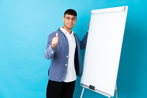 Homme colombien donnant une présentation sur tableau blanc avec le pouce vers le haut