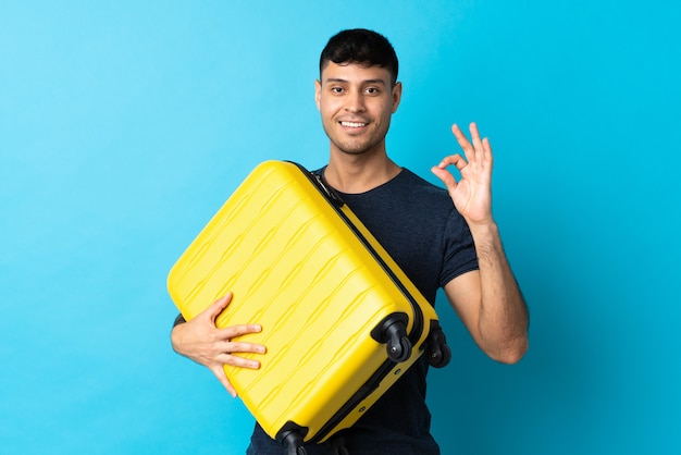 Homme colombien isolé avec valise de voyage