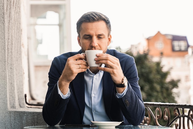 Homme comme le café Bel homme avec une tasse de café au café Mode de vie matinal de l'homme