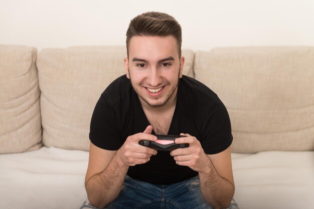 Homme compétitif jouant à des jeux vidéo et excité heureux joyeux à la maison