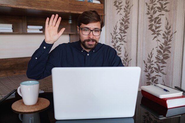 Homme concentré assis au bureau en regardant le cours vidéo du webinaire