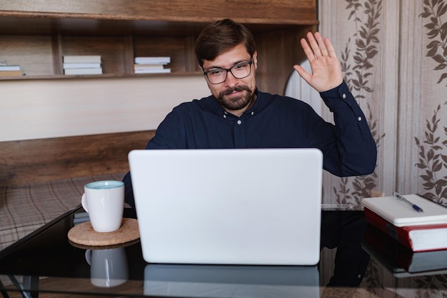 Homme concentré assis au bureau en regardant le cours vidéo du webinaire