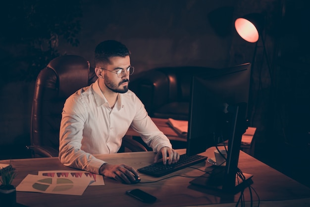 homme concentré concentré assis travail en tapant pc