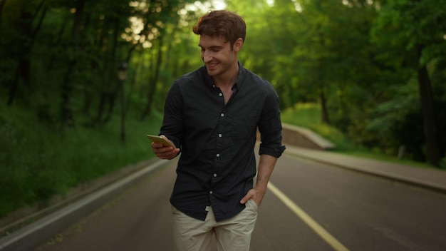 Homme concentré envoyant un message texte à l'extérieur