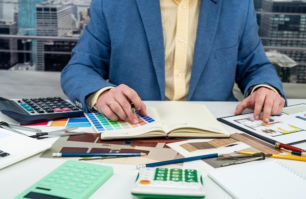 L'homme de concepteur choisit des couleurs pour le travail de bureau sur le dessin d'appartement