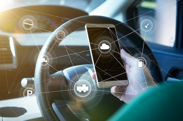 Homme conducteur utilisant un système de contrôle de voiture autonome intelligent sur un téléphone portable Concept de technologie de conduite futuriste