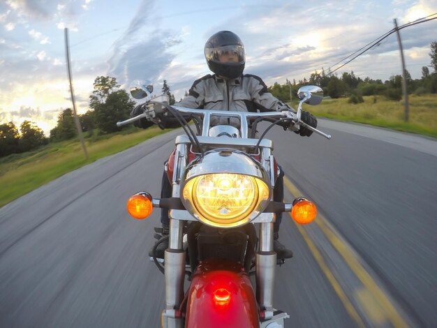 Homme conduisant une moto pendant un coucher du soleil vibrant