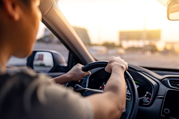 Homme conduisant une voiture le long de l'autoroute avec le soleil brille dans le pare-brise