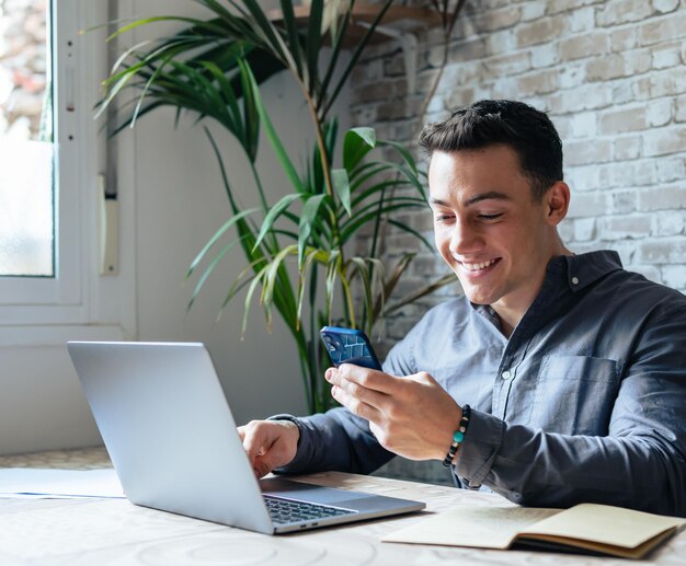 Photo un homme confiant assis à son bureau prend une pause au travail avec des documents électroniques sur son ordinateur portable