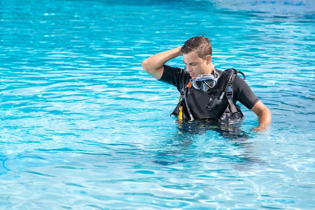 Homme confus exerçant dans la piscine avant la plongée sous-marine