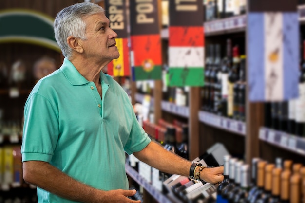 homme de consommation choisissant des vins dans un supermarché. Homme brésilien.