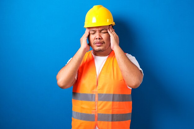 Homme de constructeur asiatique portant un uniforme de construction et un casque de sécurité isolé