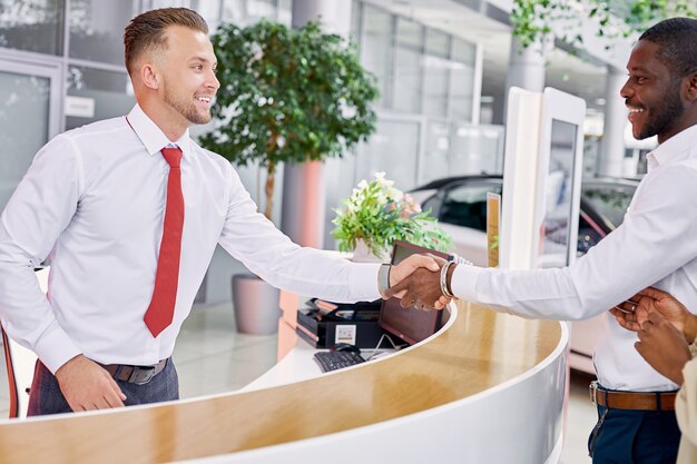 Photo homme consultant caucasien, serrer la main à l'homme afro-américain cutomer