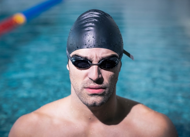 Homme contrarié portant des lunettes de natation à la piscine