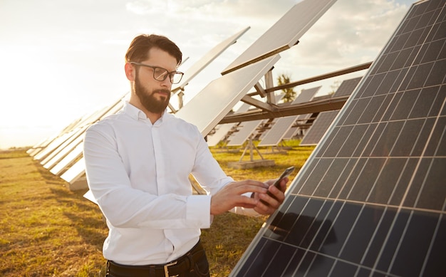 Homme contrôlant des panneaux solaires via un smartphone