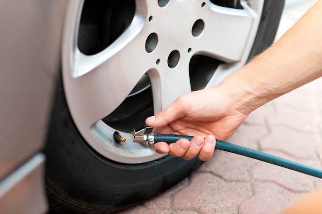 L&#39;homme contrôle la pression des pneus de sa voiture