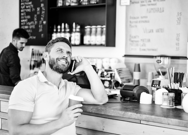 Homme conversation mobile café barista arrière-plan Boire du café en attendant Vous attendre Homme smartphone commander du café au café Concept de pause café Option de café à emporter pour les personnes occupées