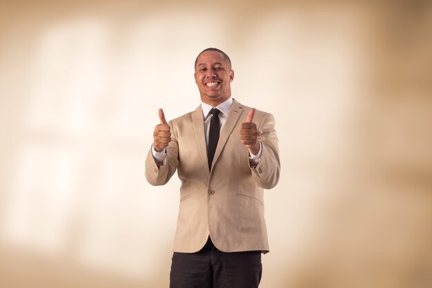 Homme en costume d'affaires beige en photo de studio sur un fond avec des lumières.