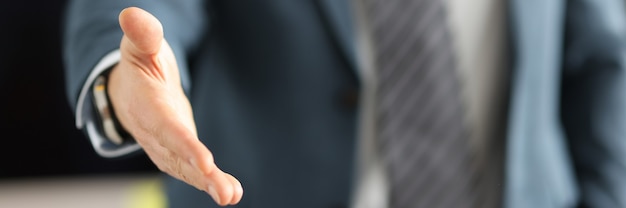 Homme en costume d'affaires donnant sa main pour le concept d'affaires en gros plan de la poignée de main