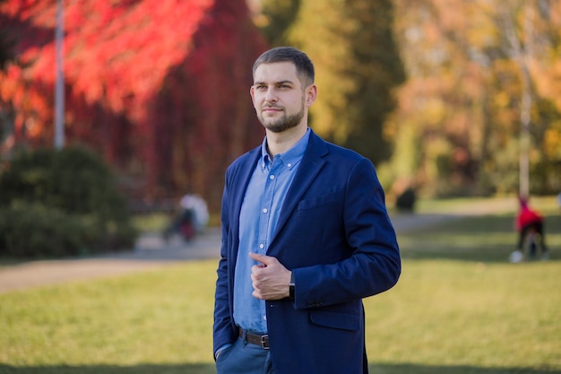 Homme en costume à l'automne dans le parc