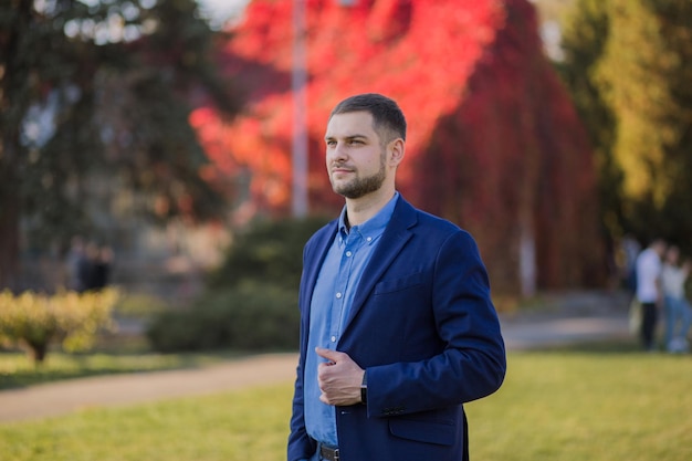 Homme en costume à l'automne dans le parc