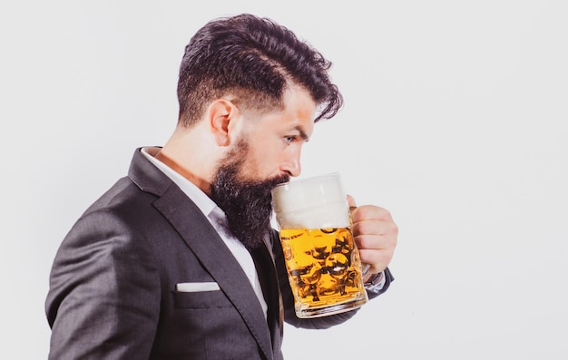 Homme en costume classique buvant de la bière barbu en tenue d'affaires a l'air heureux et satisfait portrait