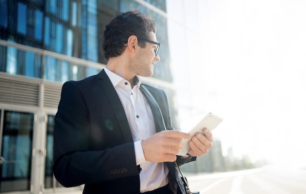 Un homme en costume formel se rend au bureau pour travailler utilise un espace tablette pour copier