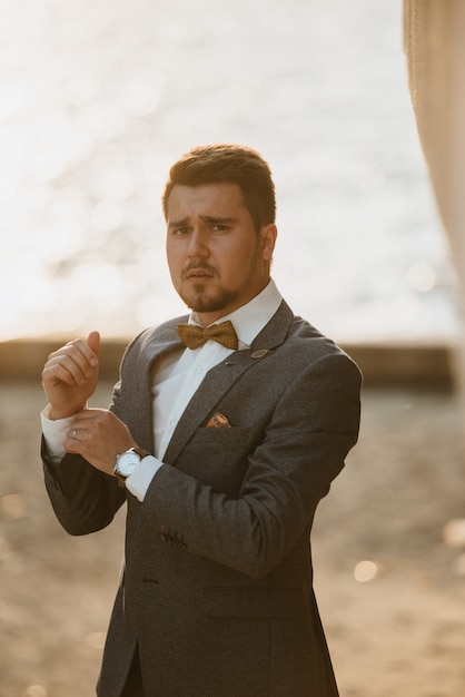 Un homme en costume gris pose dans la rue pour faire de la publicité pour les vêtements pour hommes. Prise de vue pour magasin de vêtements pour hommes