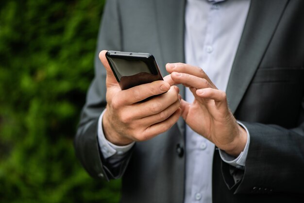 Homme en costume gris avec un smartphone