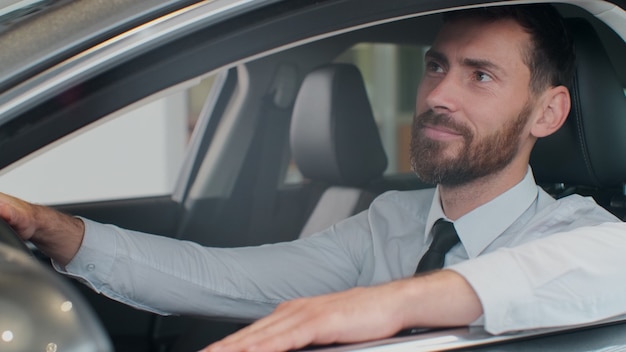 Homme en costume à l'intérieur de la voiture