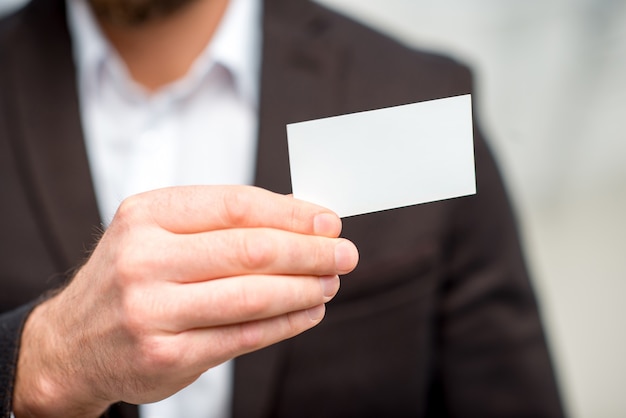 Homme en costume montrant la carte de visite. Vue rapprochée sur la carte vide à copier coller