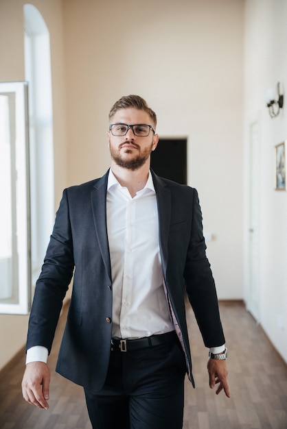 Un homme en costume noir et chemise blanche pose à l'intérieur pour la publicité de vêtements pour hommes. Prise de vue pour magasin de vêtements pour hommes