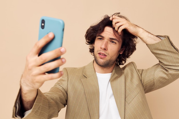 Homme en costume posant des émotions en regardant le fond isolé du téléphone