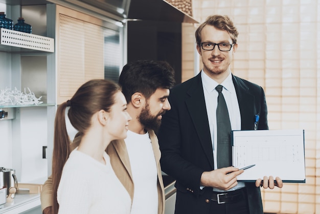 Homme En Costume, Regardant La Caméra Montrant Les Plans Aux Clients.