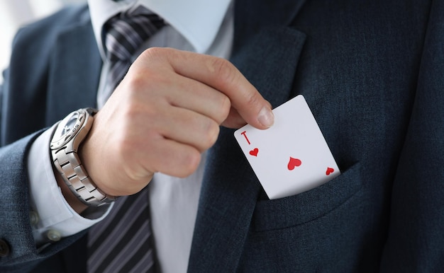 Photo un homme en costume sort une carte d'as de sa poche de veste.