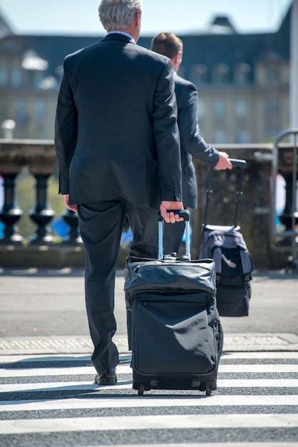 Homme en costume tirant la valise