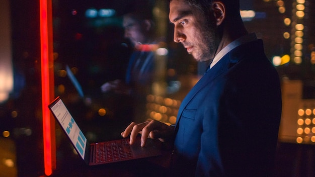 Un homme en costume utilise un ordinateur portable Microsoft Surface.